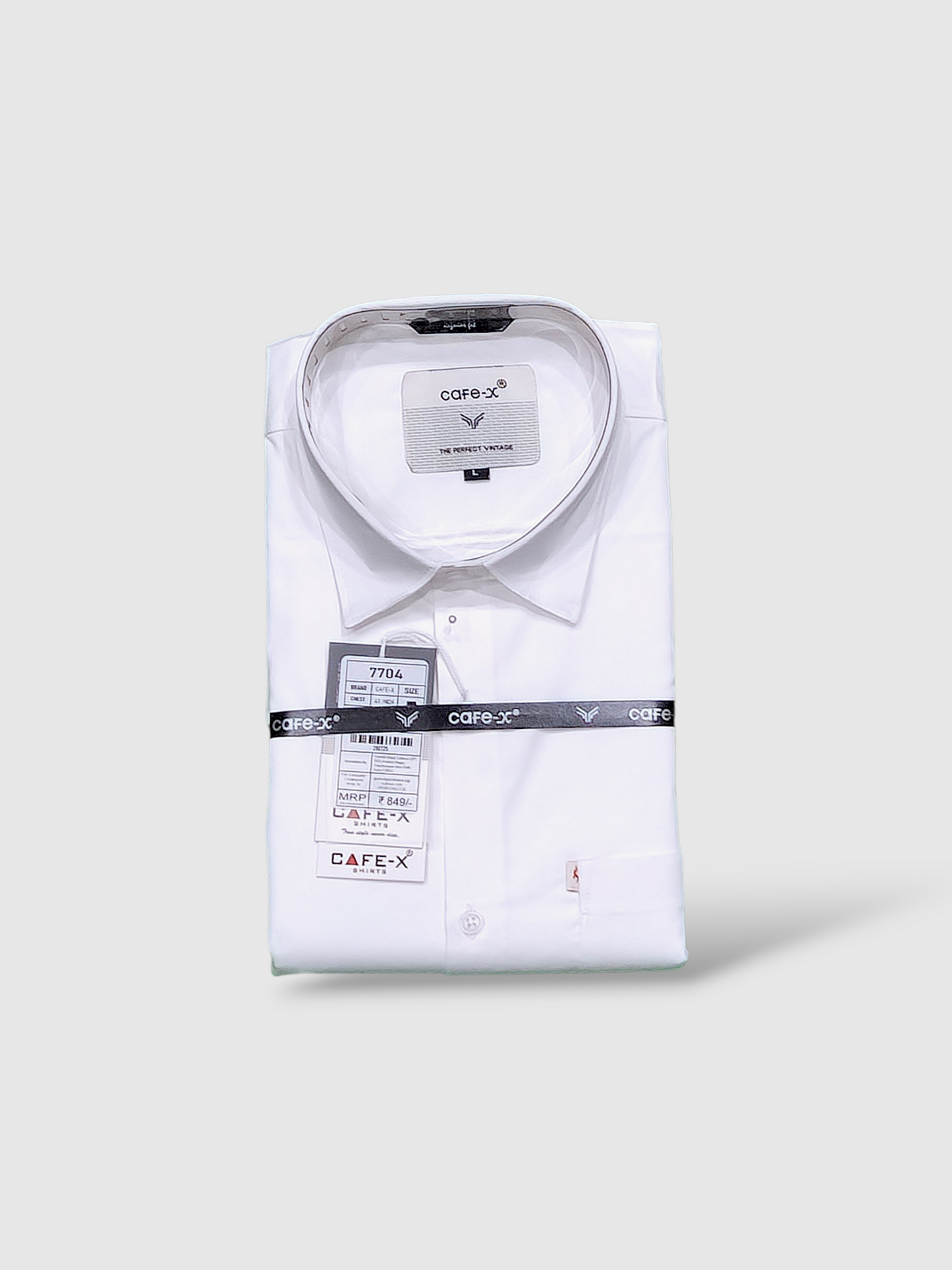 Folded white shirt with Cafe-X labels on a light gray background
