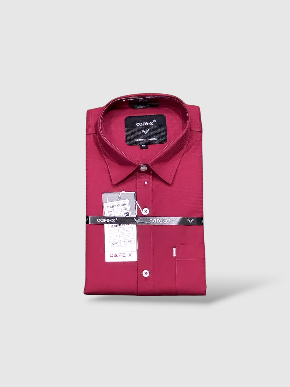 Red dress shirt with Cafe X tags on a light gray background