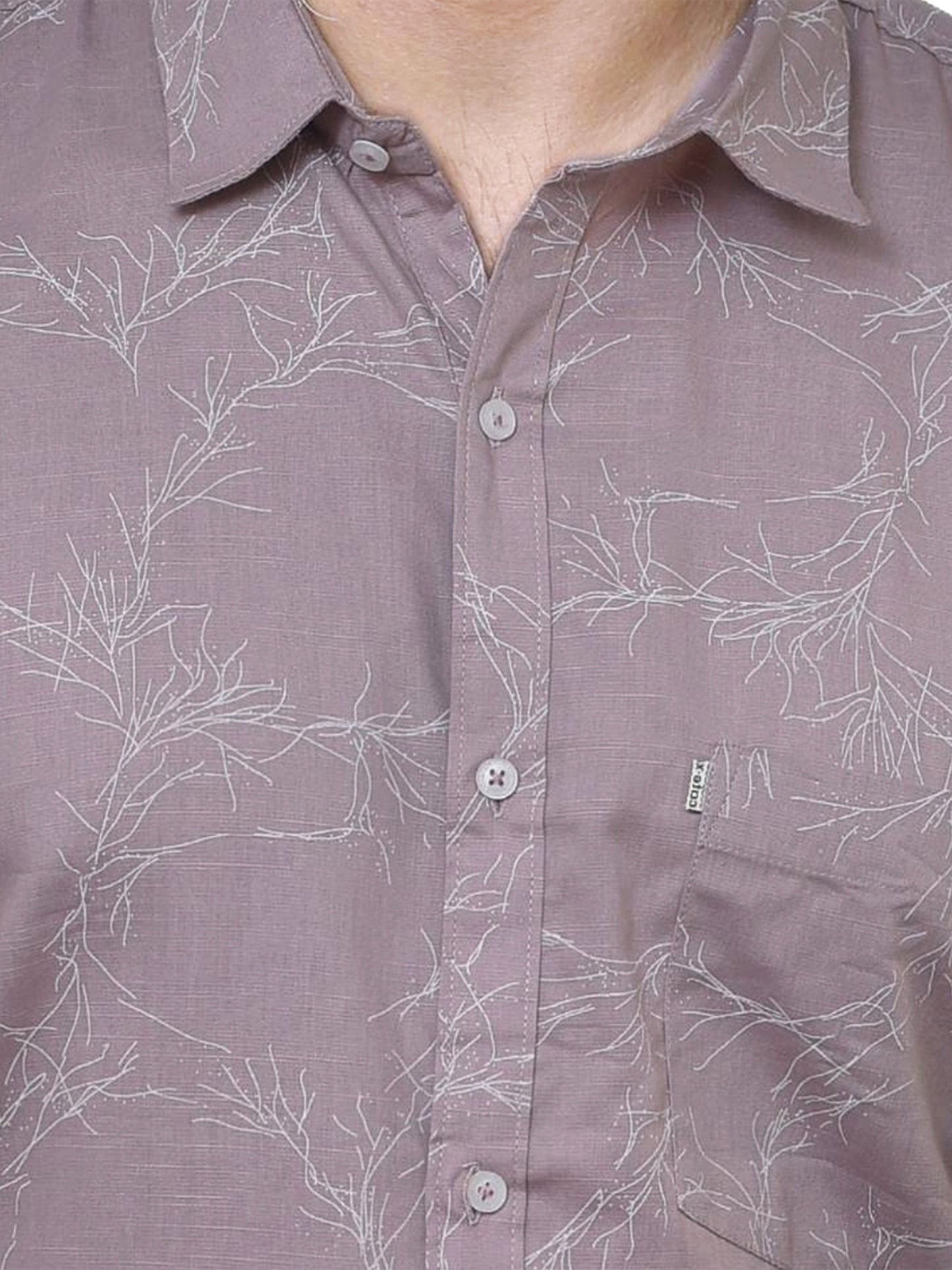 Close-up of a brown shirt with white floral pattern