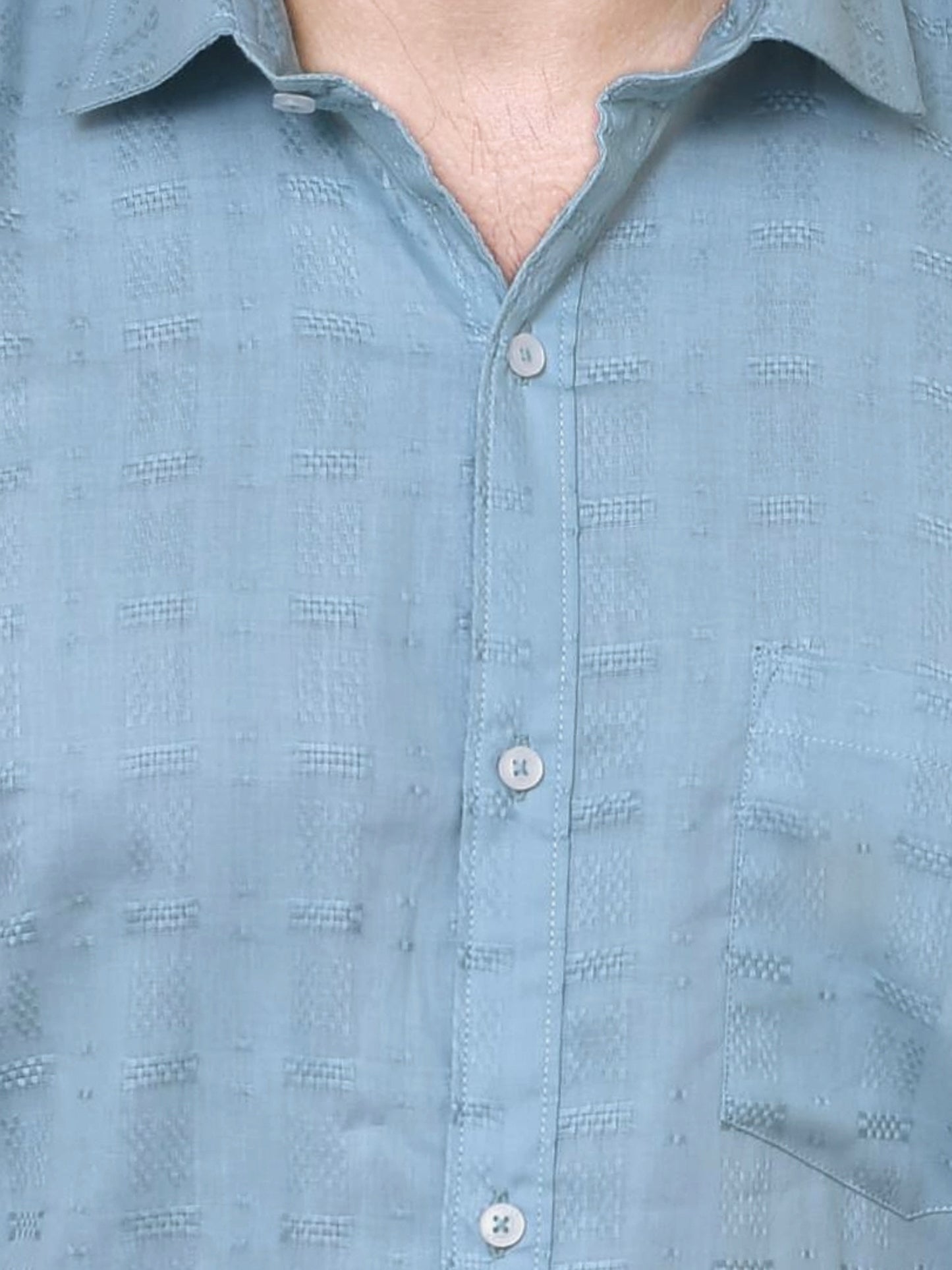 Close-up of a light blue shirt with a subtle pattern