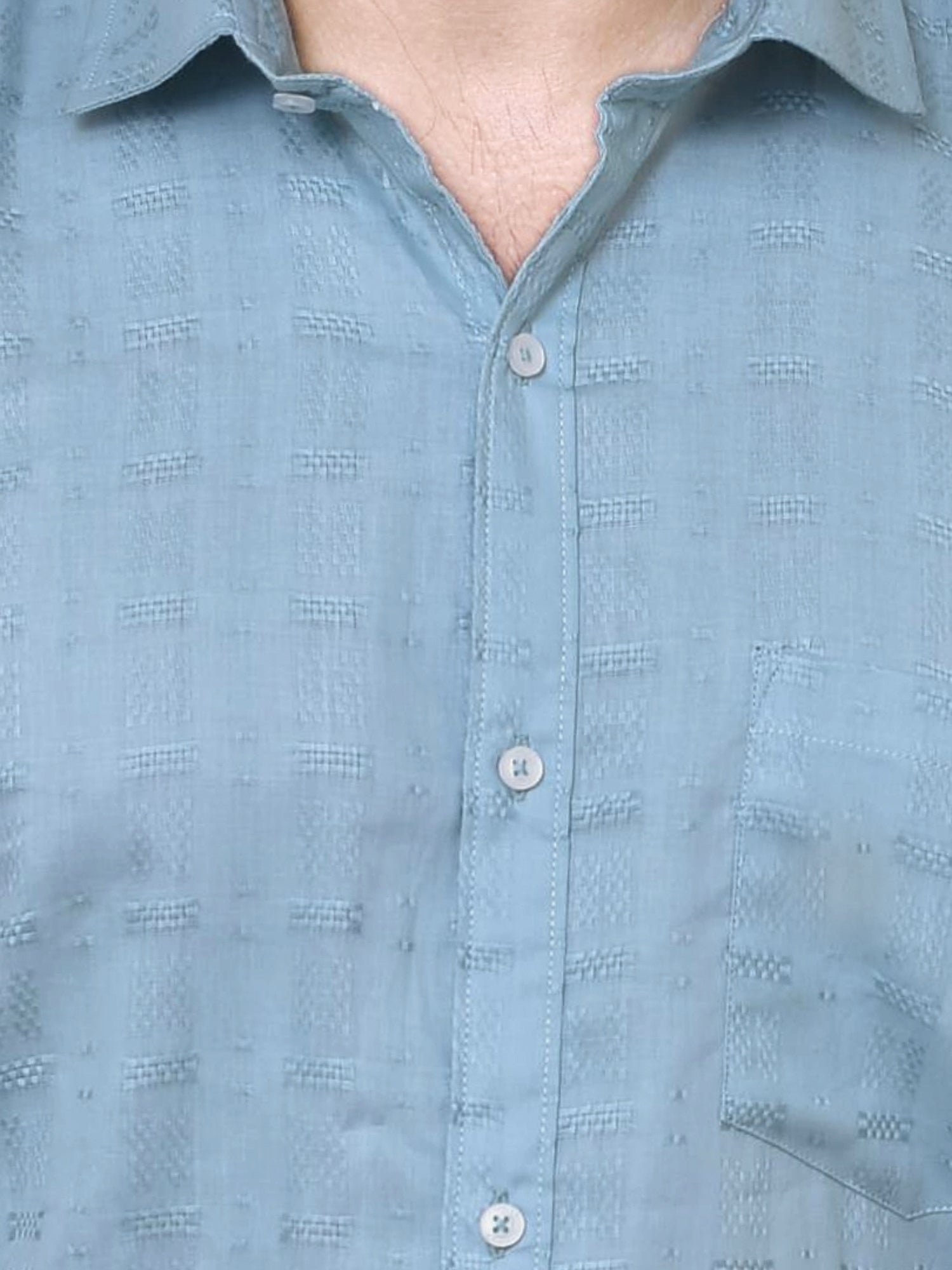 Close-up of a light blue shirt with a subtle pattern